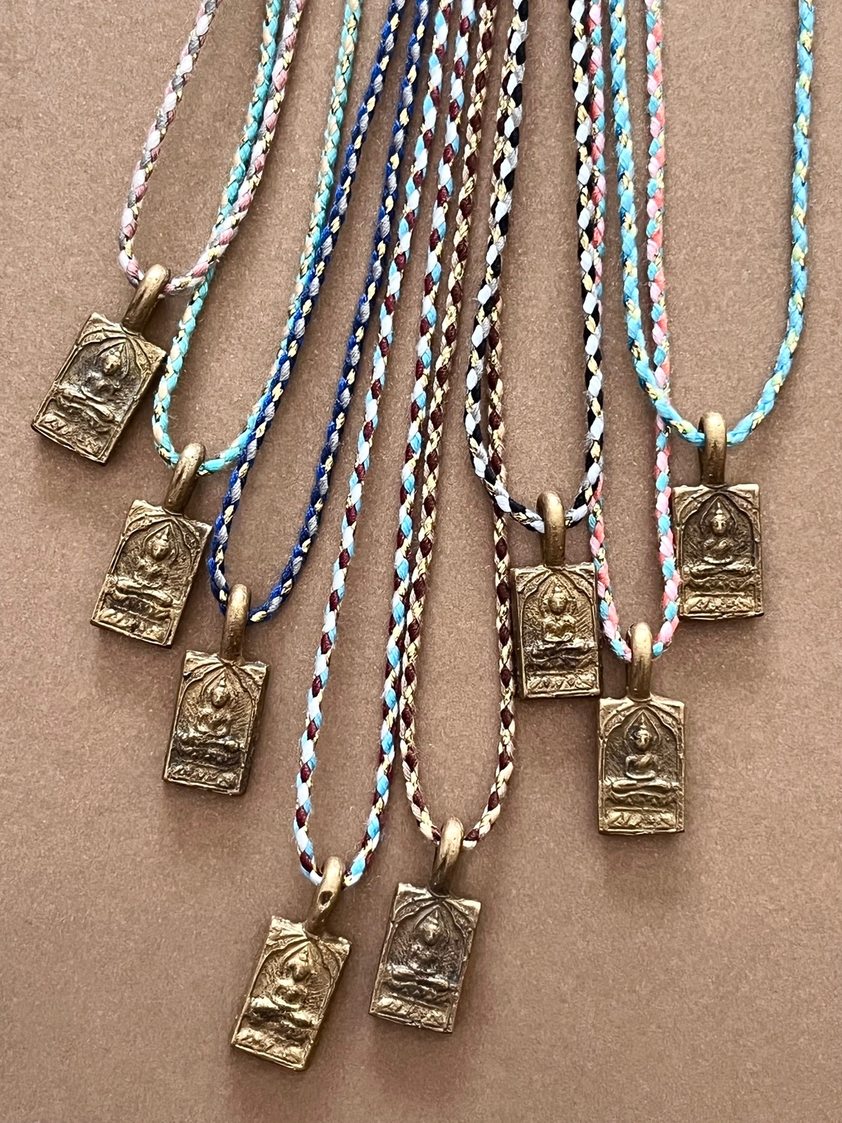 be here now necklace with a hand-picked brass amulet from a thai temple as a pendant depicting the buddha seated in awareness and colorful golden cord