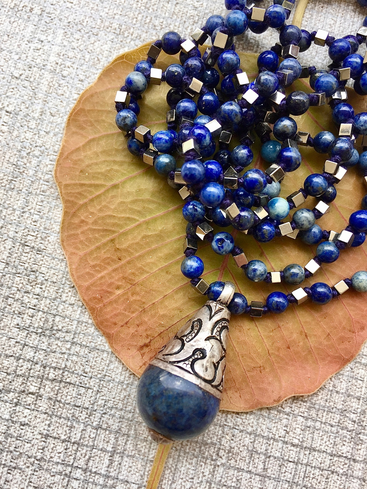afghan drop necklace with deep blue lapis beads, silver hematite cubes, and vintage afghani teardrop pendant with intricate silver detailing