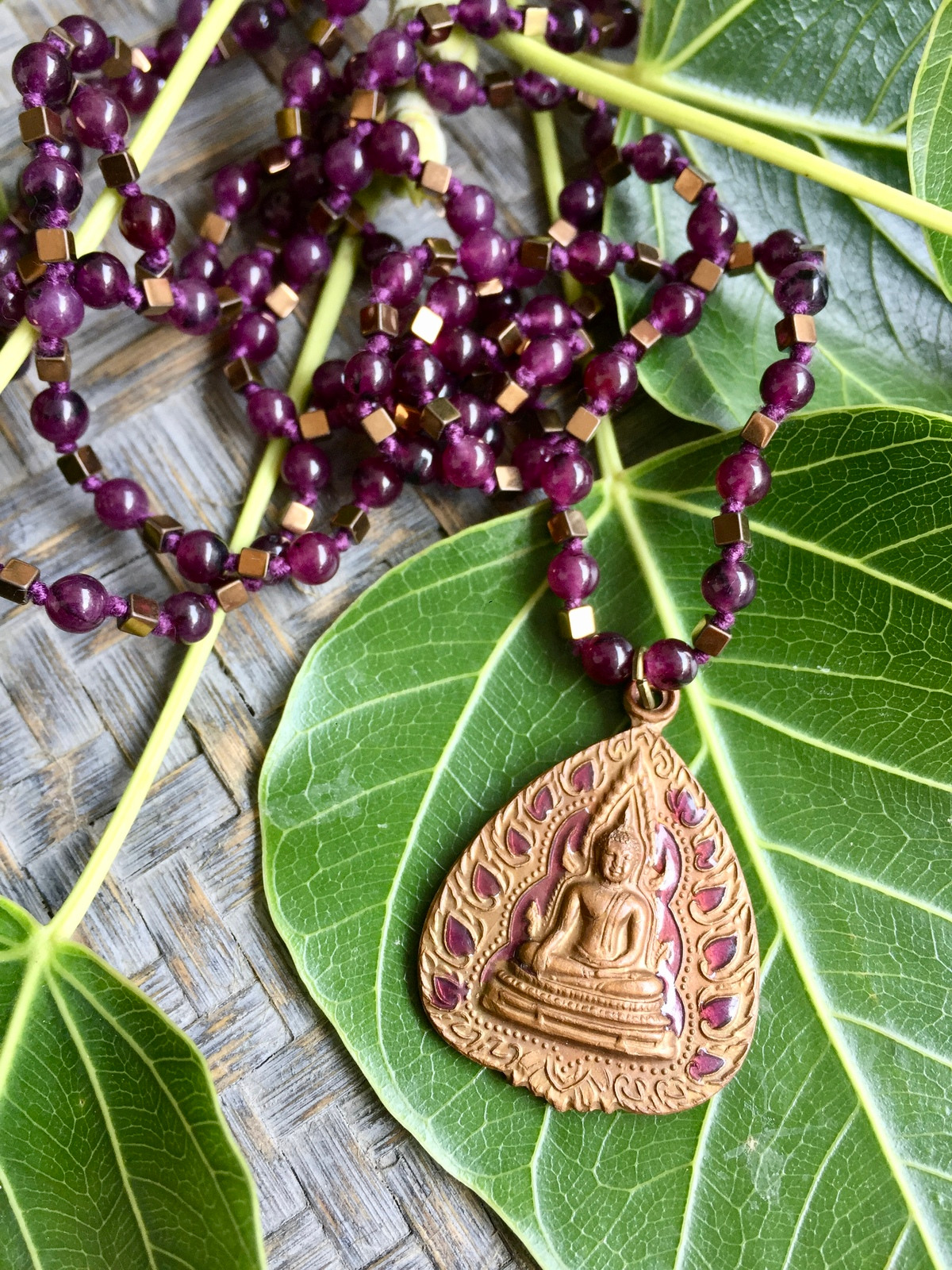 buddha energy necklace handcrafted with deep purple agate and bronze hematite beads, featuring an antique bronze thai buddha amulet with purple enamel details, symbolizing spiritual energy, balance, and mindfulness