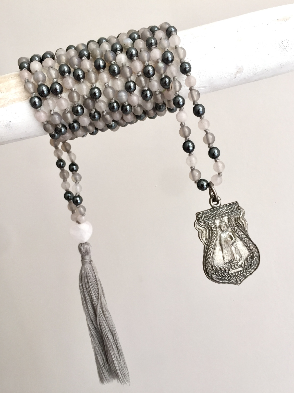 buddha harmony double mala handcrafted with tiny grey agate and gunmetal hematite beads, featuring a faceted rose quartz heart guru bead and a brass buddhist amulet with silver finish, symbolizing love, balance, and mindfulness