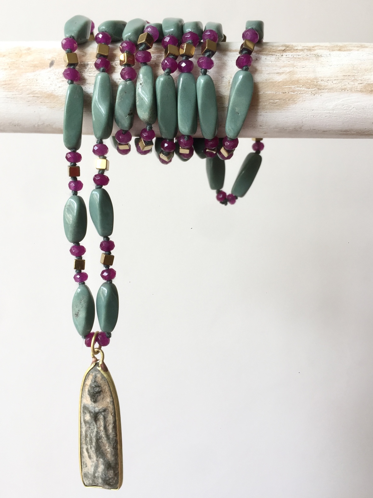 buddha wisdom necklace made with smooth green aventurine beads, deep purple agate accents, and golden hematite cubes, featuring a central hand-carved thai buddha stone amulet framed in gold.
