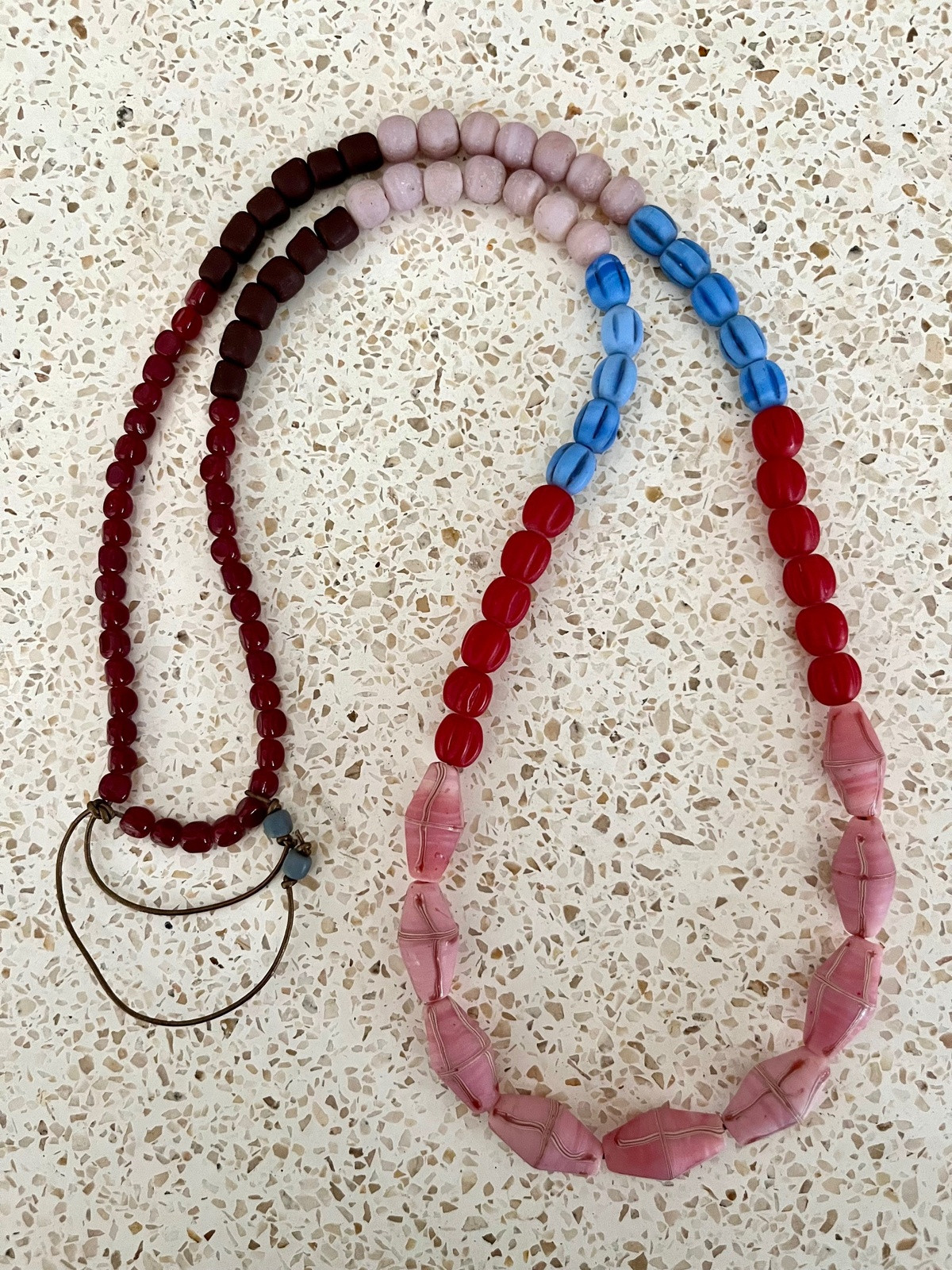 java necklace with pink, red and blue handmade javanese glass beads in different shapes on a leather strap inspired by indonesian textiles