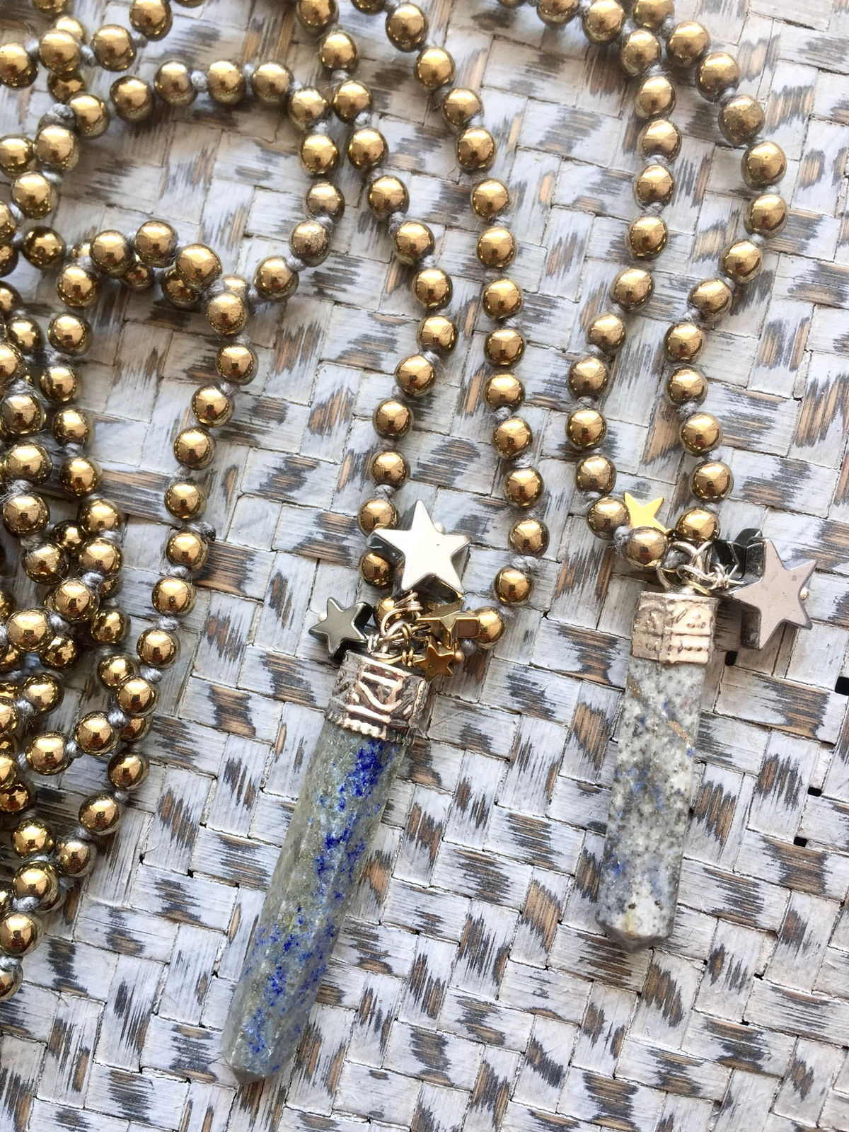 stars sparkle necklace made with hand-knotted 4mm golden hematite beads and a lapis crystal pendant with golden sparkles, decorated with four hematite stars in silver, gold, and gunmetal