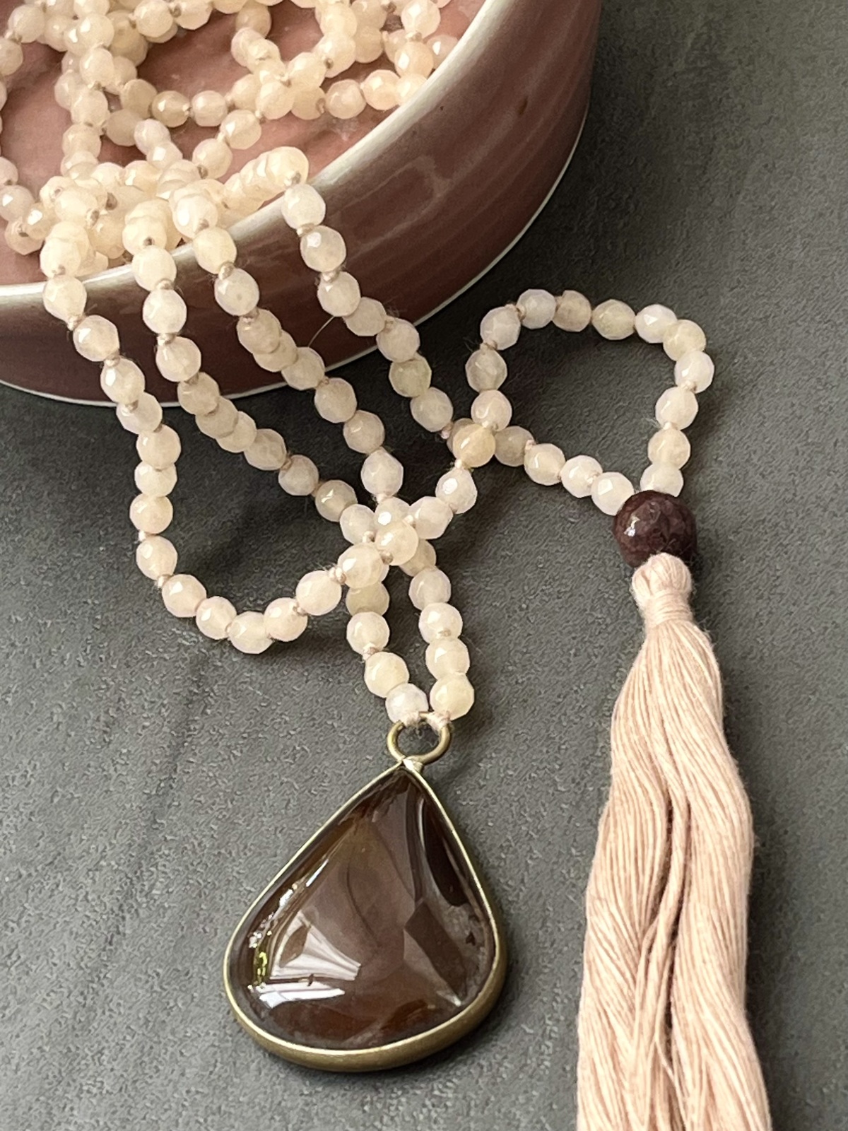 adjustable double mala necklace with hand-knotted cream agate beads and brown onyx pendant, symbolizing stability, grounding, and refined balance