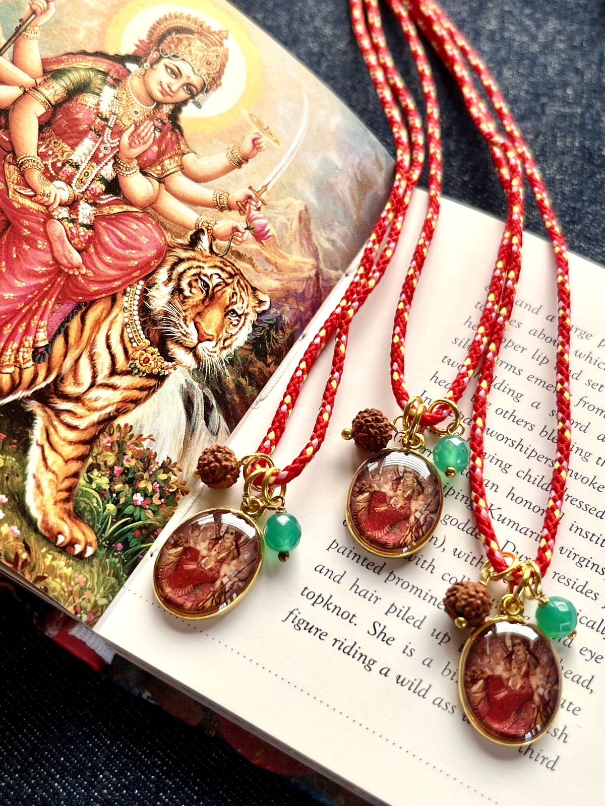 colorful durga funky cord necklace with adjustable red pop cord, vintage golden pendant of goddess durga, rudraksha seed, and agate bead, a vibrant accessory symbolizing strength, protection, and fearless energy