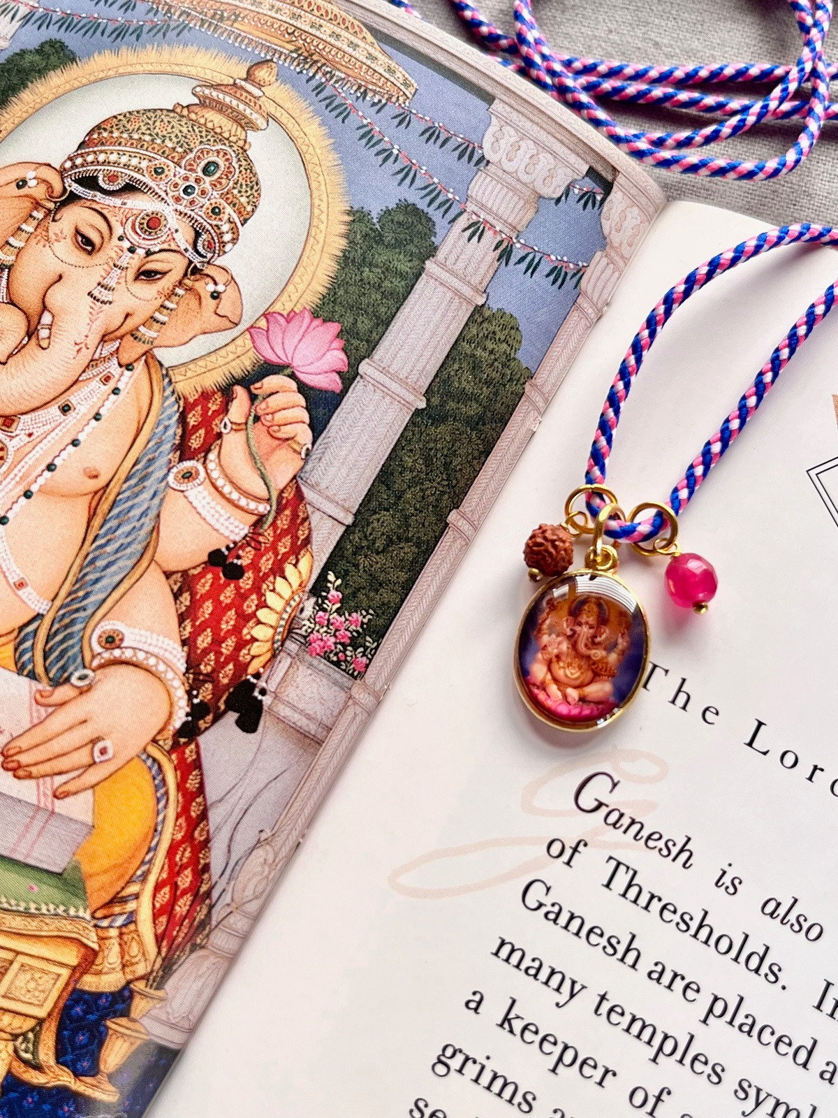 colorful ganesh funky cord necklace with adjustable blue pink pop cord, vintage golden pendant of god ganesh, rudraksha seed, and agate bead, a vibrant accessory symbolizing protection, positive energy, and blessing