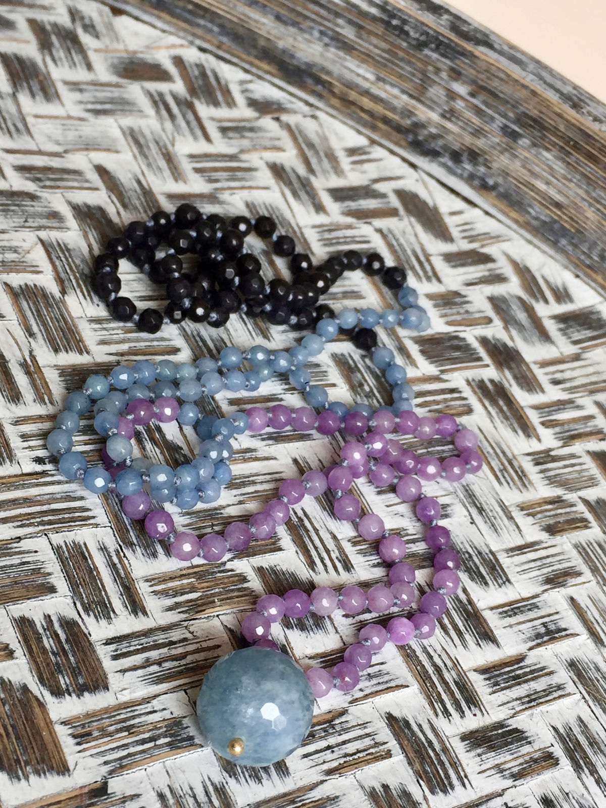 globe necklace with hand-knotted pink baby blue midnight blue agate beads and a round faceted stone pendant symbolizing the globe, featuring a chic minimal design