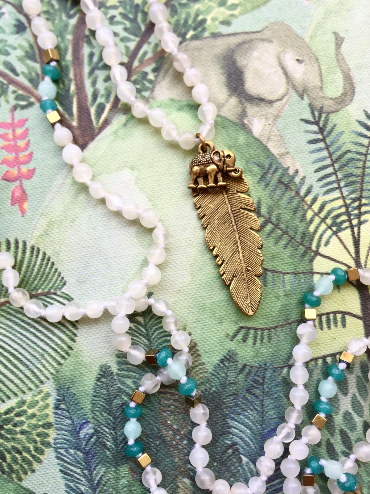 moonstone and green agate necklace with brass elephant and feather pendant, inspired by jungle life between india and bali
