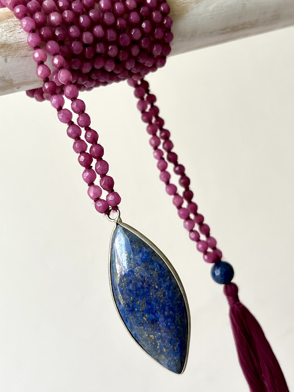 adjustable double mala necklace with hand-knotted dark pink agate beads and a deep blue lapis pendant, symbolizing wisdom, intuition, and elegant balance